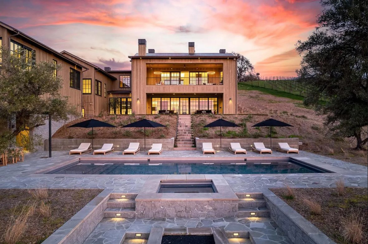 3281 Napa Road — south elevation at dusk, looking back at the house from the pool terrace with the vineyard at right.